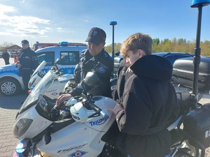 policjant i młodzi mężczyźni oglądający motocykl policyjny