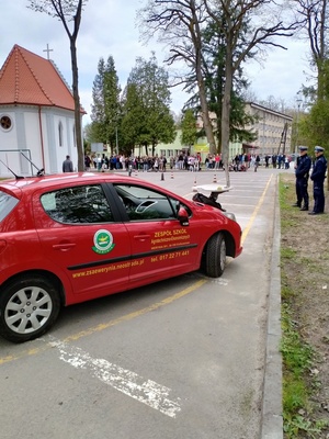 uczestnik turnieju podczas jazdy czerwonym samochodem po placu manewrowym