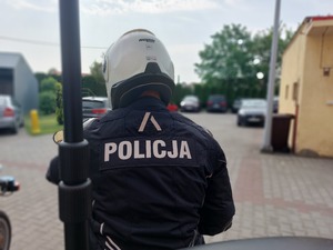 Policjanci w kombinezonach i kaskach siedzący na motocyklach