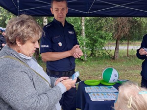 policjant oraz kobieta czytająca ulotkę