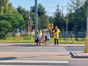 policjantka razem z Panem &quot;Stopkiem&quot; przeprowadzająca dzieci przez jezdnię