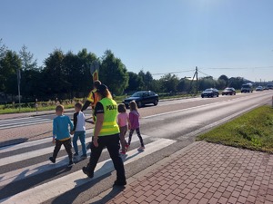 policjanta przeprowadzająca dzieci przez jezdnię