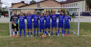 kolbuszowscy policjanci w strojach sportowych stojący na boisku sportowym przed przed bramką