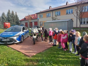 dzieci stojące obok policyjnego radiowozu i motocykla,