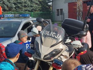 dzieci stojące obok policyjnego radiowozu i motocykla,