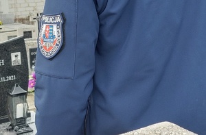 policjanci stojący przed dębem pamięci oraz przed grobem