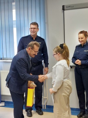 zdjęcia z wręczenia nagród w konkursie &quot;Bezpieczne wakacje&quot;. na zdjęciach I Zastępca Komendanta Powiatowego wraz z zaproszonymi gośćmi oraz dzieci biorące udział w konkursie podczas wręczania nagród