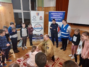 policjantka na spotkaniu z uczestnikami półkolnoni, na zdjęciu widać grupę dzieci i policjantkę