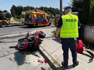 policjant obok uszkodzonego motocykla