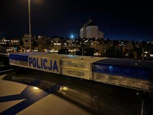 napis policja na tle cmentarza
