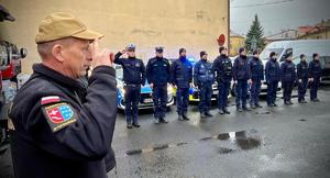 Policjanci stoją ustawieni w szeregu wspólnie ze strażakami.
